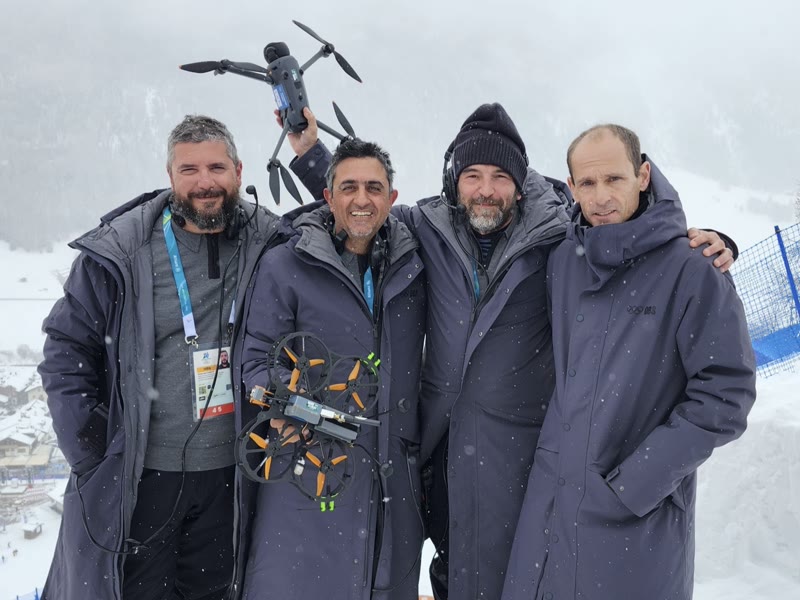 The FPV pilot team with their drones on the snow